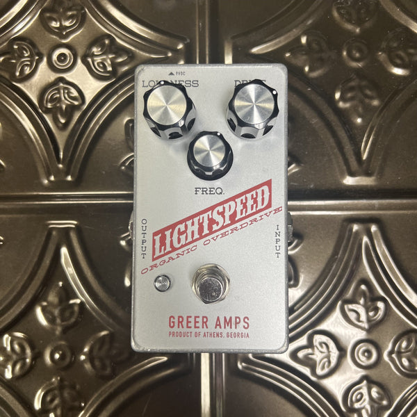 Guitar effects pedal with 'Greer Amps' branding on a decorative metal surface