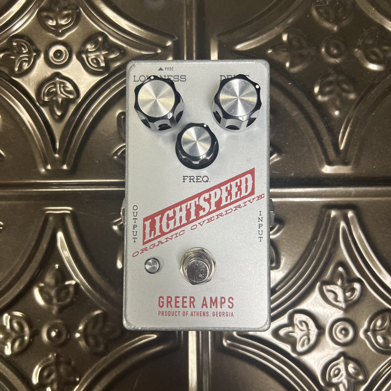 Guitar effects pedal with 'Greer Amps' branding on a decorative metal surface